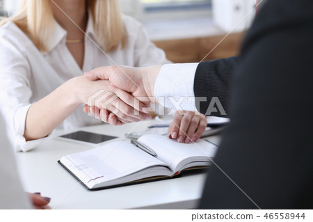 Businessman and woman shake hands Businessman and woman shake hands 46558944