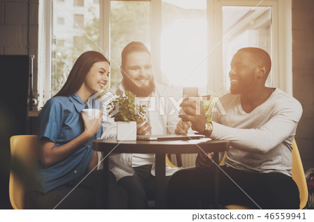 A company of friends sits in a cafe at the table A company of friends sits in a cafe at the table 46559941
