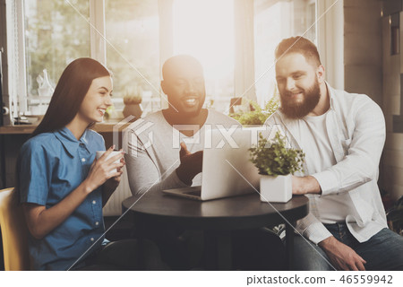 A company of young people working for a laptop A company of young people working for a laptop 46559942