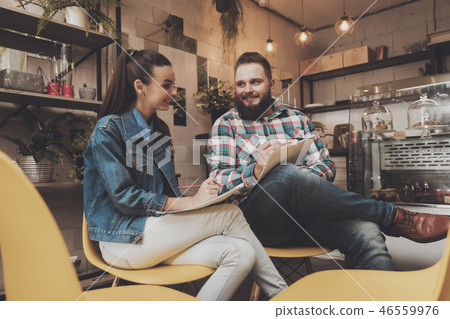Young people studying documents while in a cafe Young people studying documents while in a cafe 46559976