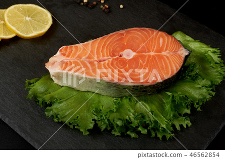 Raw salmon steak and spices on slate plate ready for cooking. Raw salmon steak and spices on slate plate ready for cooking. 46562854