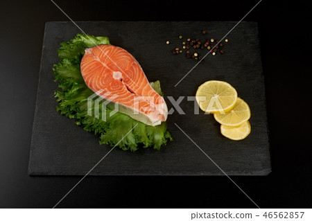 Raw salmon steak and spices on slate plate ready for cooking. 46562857