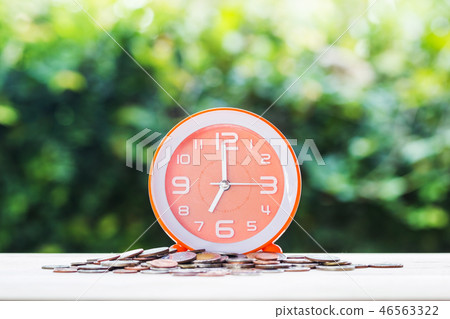 Stacking growing coins and orange clock on money. Stacking growing coins and orange clock on money. 46563322