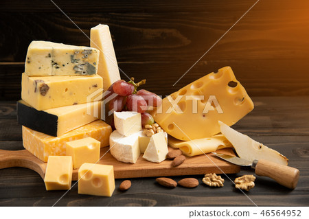 Various types of cheese on a rustic table 46564952