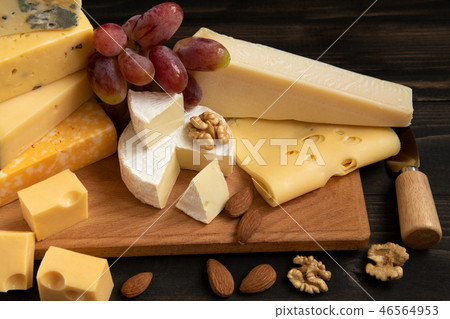 Various types of cheese on a rustic table 46564953
