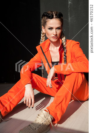 beautiful fashionable woman with braids in Orange overalls 46570152
