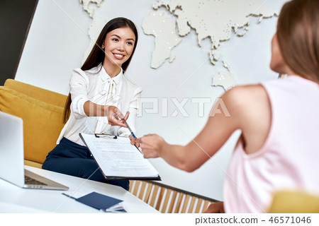 Young woman smiling and giving contract to tourist. Young woman smiling and giving contract to tourist. 46571046