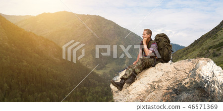 A tourist on a high mountain looks at nature. 46571369