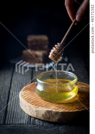 Honey dripping in glass jar Honey dripping in glass jar 46571382