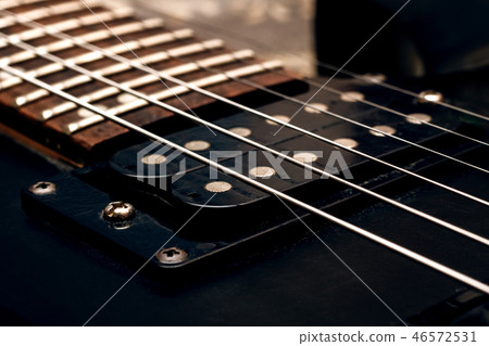Wooden neck of a black guitar close up Wooden neck of a black guitar close up 46572531