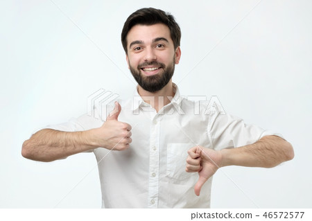 Man trying to make a desicion making good or bad sign. Man trying to make a desicion making good or bad sign. 46572577