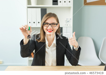 New home and real estate concept - Happy realtor woman giving you keys and showing thumb up New home and real estate concept - Happy realtor woman giving you keys and showing thumb up 46573419