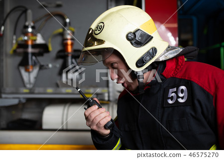 Image of man firefighter in helmet talking on radio 46575270