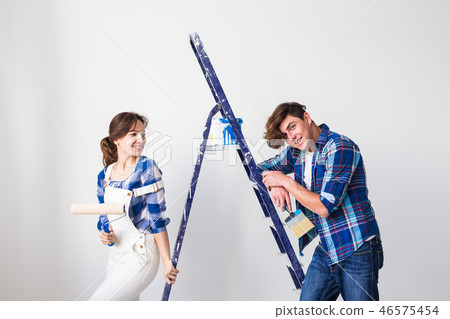 Repair, renovation and love couple concept - Young woman and man doing repair with happy faces Repair, renovation and love couple concept - Young woman and man doing repair with happy faces 46575454