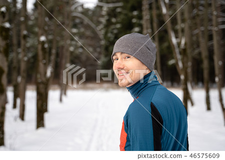 Portrait of a runner from the back, dressed in warm sportswear and preparing to run Portrait of a runner from the back, dressed in warm sportswear and preparing to run 46575609