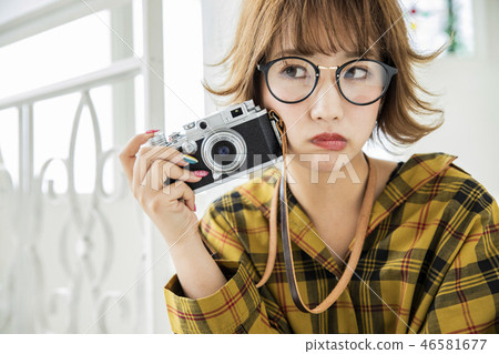 相機女性的眼鏡在女性的蜂蜜頭髮之外 相機女性的眼鏡在女性的蜂蜜頭髮之外 46581677