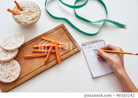 Making a new delicious recipe from hummus with carrot sticks. Making a new delicious recipe from hummus with carrot sticks. 46583142