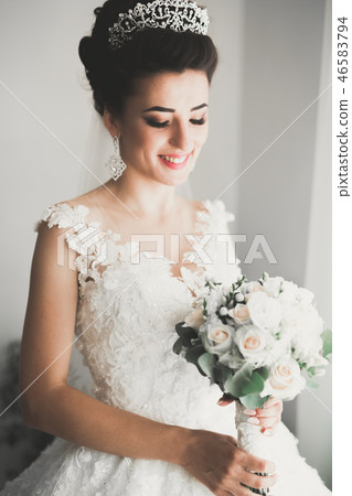 Gorgeous bride in robe posing and preparing for the wedding ceremony face in a room Gorgeous bride in robe posing and preparing for the wedding ceremony face in a room 46583794