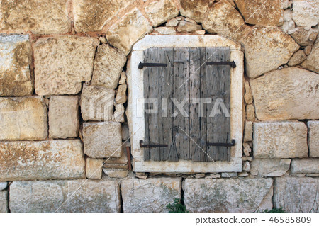 Closed window at the old stone house 46585809