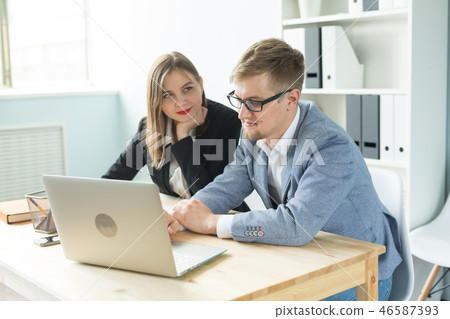 Business people, team work and office concept - woman and man are working at startup project Business people, team work and office concept - woman and man are working at startup project 46587393