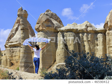 A young woman stands in the wind between huge A young woman stands in the wind between huge 46590412