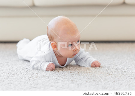 Childhood, infant and people concept - baby girl learning to crawl on the floor 46591785