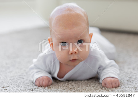 Baby, childhood, people concept - Portrait of a crawling baby on the floor 46591847
