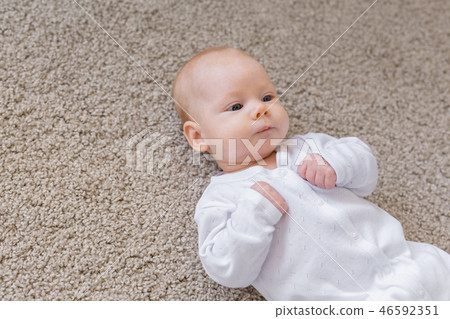 Family, baby and infant concept - Close up portrait of little child on the floor 46592351