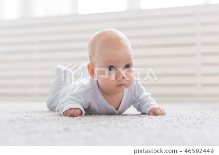 Childhood, infant and people concept - baby girl learning to crawl on the floor 46592449