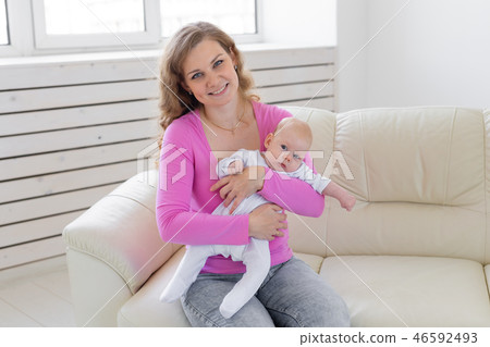 Childhood, motherhood, infant concept - happy mother holding her baby 46592493
