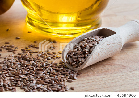 Linseed on a wooden table, with flaxseed oil 46594900