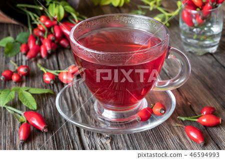 A cup of rose hip tea with fresh rose hips 46594993