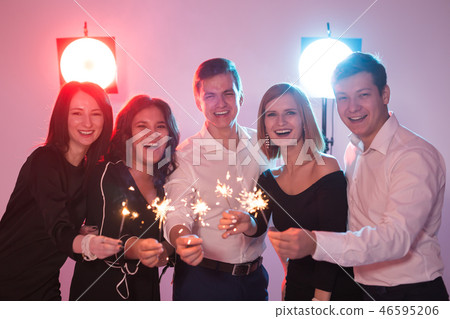Celebrating with fun. Group of cheerful young men and women carrying sparklers. New year, holidays 46595206