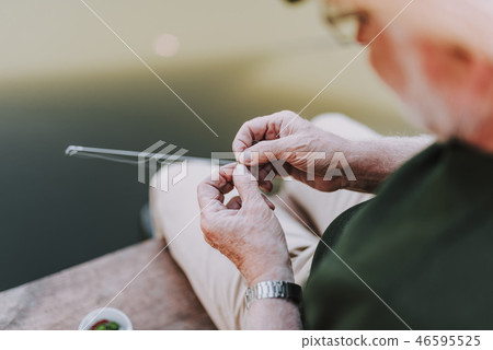 Aged angler putting the bait on the hook 46595525