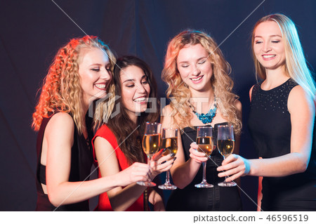 Party, holidays, celebration and new year eve concept - Cheerful young woman clinking glasses of Party, holidays, celebration and new year eve concept - Cheerful young woman clinking glasses of 46596519