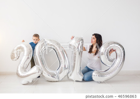 New 2019 Year is coming concept - Mother with her baby son sitting near silver colored numbers 46596863