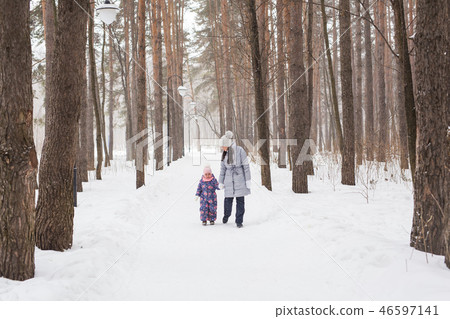 Motherhood, children and nature concept - Attractive young woman and adorable child walking in park 46597141