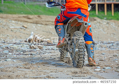 Professional Motocross Motorcycle Rider Drives Over the Road Track. Professional Motocross Motorcycle Rider Drives Over the Road Track. 46597150