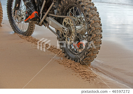 motorcycle wheels leave footprints in the wet sand on the beach motorcycle wheels leave footprints in the wet sand on the beach 46597272