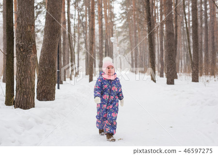 Children and nature concept - Adorable baby girl walking in winter park Children and nature concept - Adorable baby girl walking in winter park 46597275