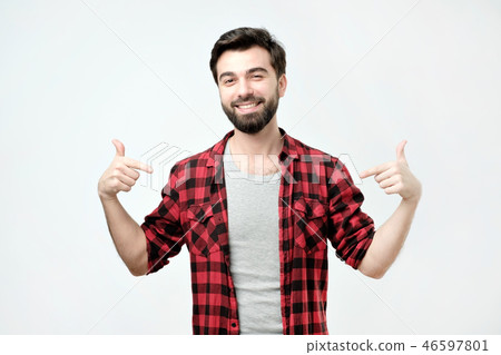 Proud young man, standing, pointing himself and looking at camera with serious egoist face Proud young man, standing, pointing himself and looking at camera with serious egoist face 46597801