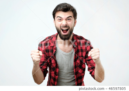 Portrait of happy spanish man with fists up celebrating his victory Portrait of happy spanish man with fists up celebrating his victory 46597805