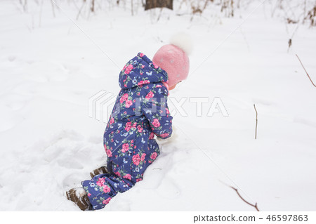 Children, winter and nature concept - Close up of adorable kid playing with snow in the park 46597863