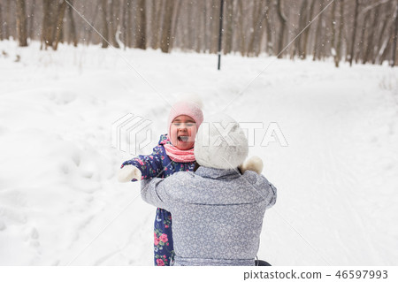 Family, childhood and nature concept - Young mother hug little daughter in the winter park 46597993