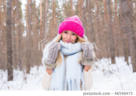 Beauty, winter and people concept - Attractive blonde woman in a pink sweater in the snowy forest is 46598473