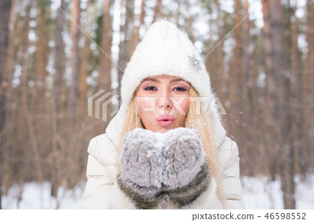 Christmas Girl portrait. Winter young woman blowing snow in winter nature 46598552