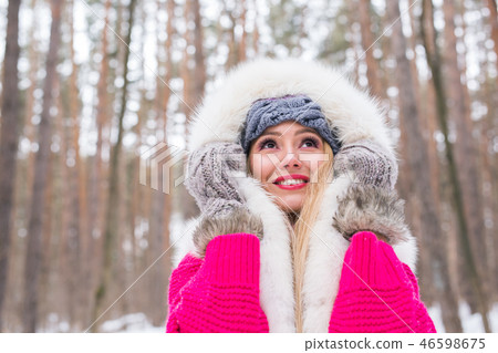 Fashion, winter and people concept - Young attractive woman dressed in fur waistcoat over snowy Fashion, winter and people concept - Young attractive woman dressed in fur waistcoat over snowy 46598675