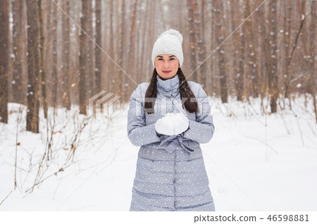 Christmas, holidays and season concept - Young beautiful smiling woman holding snow in hands in Christmas, holidays and season concept - Young beautiful smiling woman holding snow in hands in 46598881