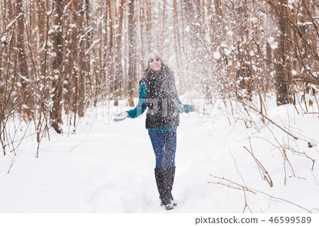 Young pretty woman throwing snow in the air in winter holidays Young pretty woman throwing snow in the air in winter holidays 46599589