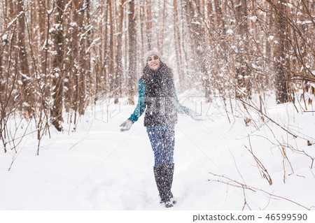 Happy young woman plays with a snow at snowy forest outdoor Happy young woman plays with a snow at snowy forest outdoor 46599590